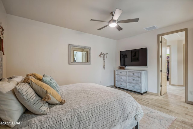 bedroom with light wood-style flooring, baseboards, visible vents, and ceiling fan