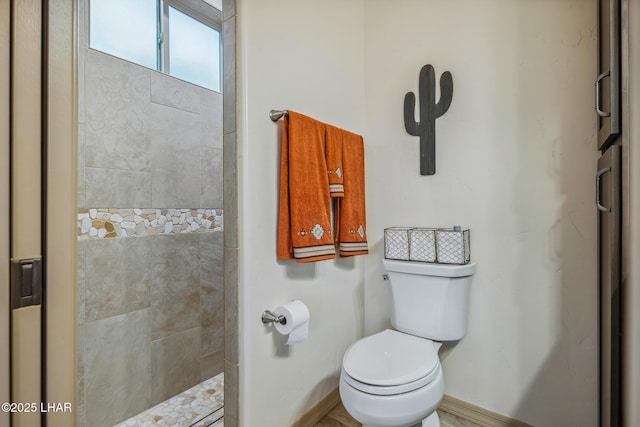 bathroom featuring baseboards, toilet, and walk in shower