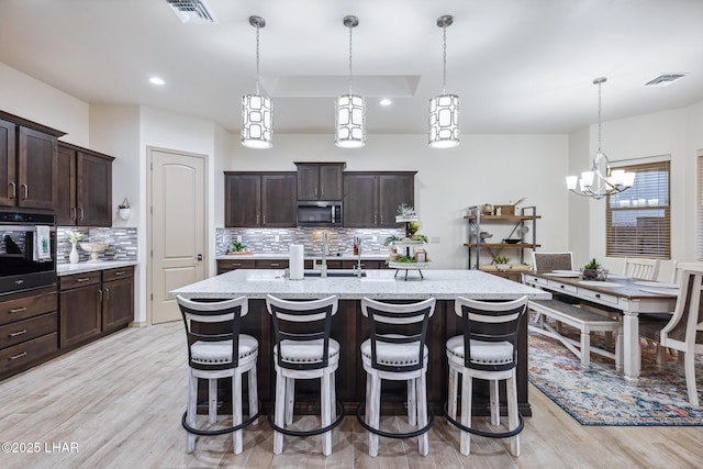 kitchen with visible vents, light stone countertops, light wood-style floors, and appliances with stainless steel finishes