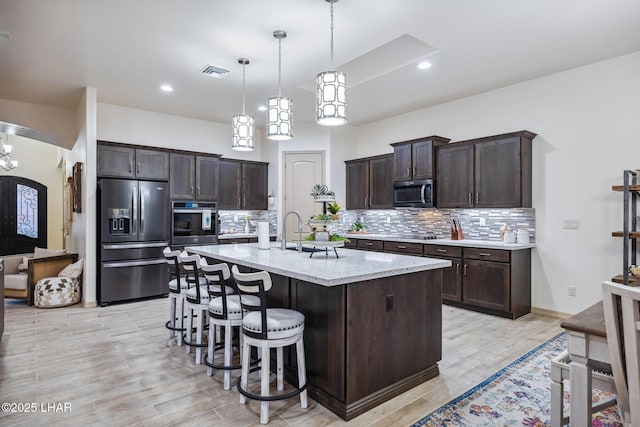 kitchen featuring backsplash, dark brown cabinets, visible vents, and appliances with stainless steel finishes