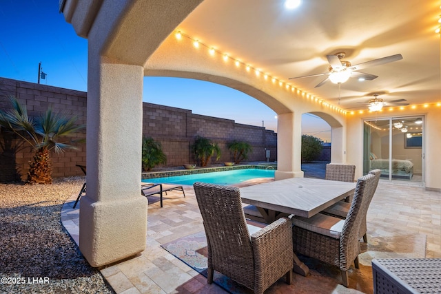 view of patio featuring outdoor dining space, a fenced in pool, a fenced backyard, and ceiling fan