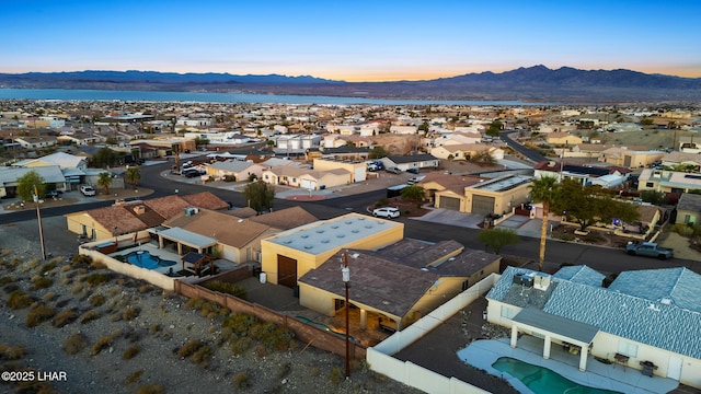 aerial view at dusk featuring a residential view and a mountain view