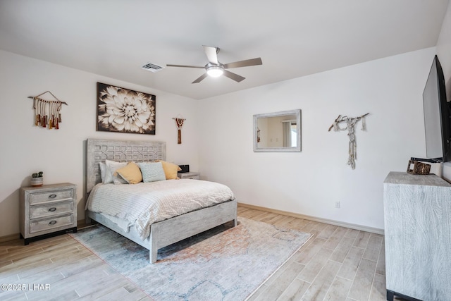 bedroom featuring wood finish floors, visible vents, baseboards, and a ceiling fan