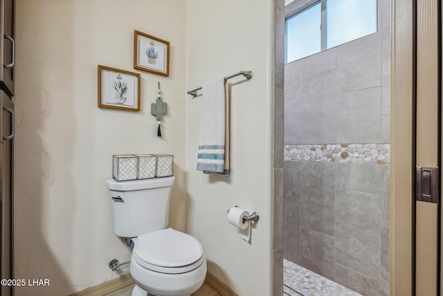 bathroom featuring toilet and tiled shower