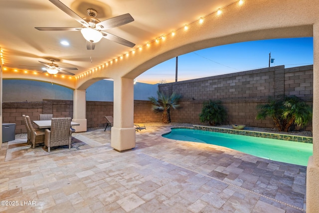 view of swimming pool with outdoor dining space, a patio, a fenced in pool, a fenced backyard, and ceiling fan