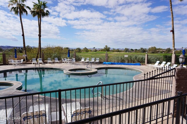 view of swimming pool featuring a community hot tub and a patio