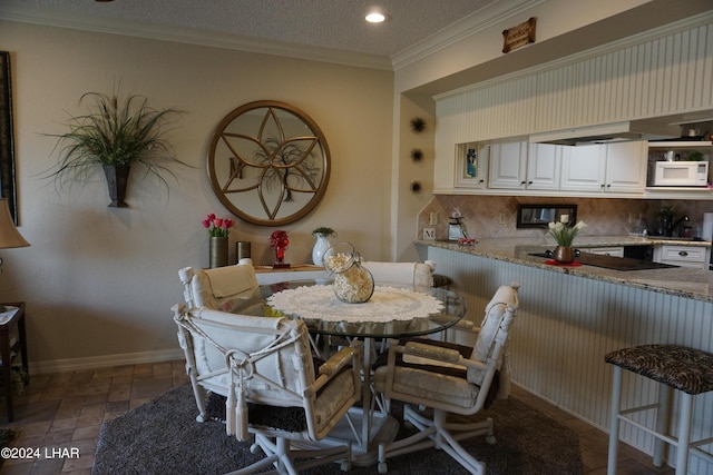 dining space with crown molding and a textured ceiling