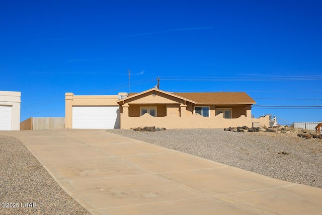 ranch-style home featuring driveway, an attached garage, and stucco siding