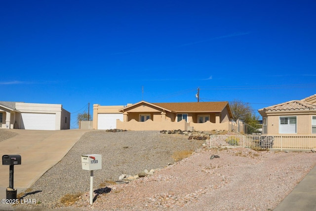 single story home featuring a garage, driveway, fence, and stucco siding