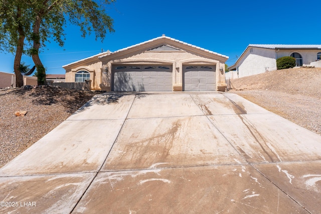 ranch-style home with an attached garage, concrete driveway, and stucco siding