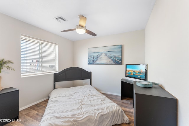 bedroom with visible vents, baseboards, a ceiling fan, and wood finished floors