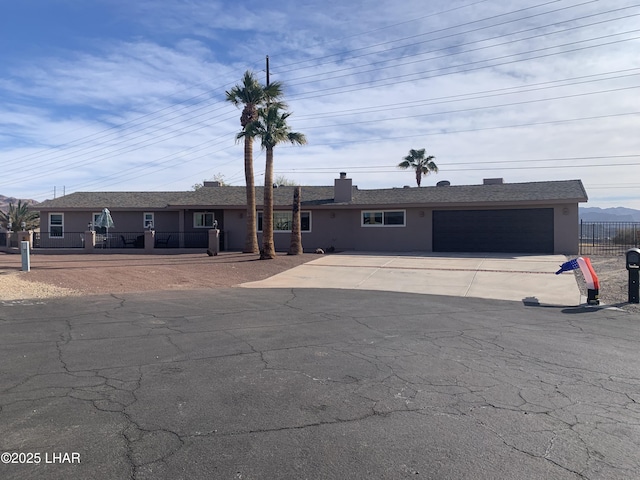 single story home with a garage, fence, driveway, and stucco siding