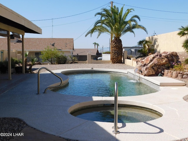 view of pool featuring pool water feature and an in ground hot tub