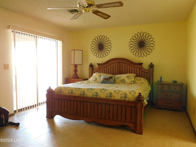 bedroom featuring multiple windows, ceiling fan, and a textured ceiling