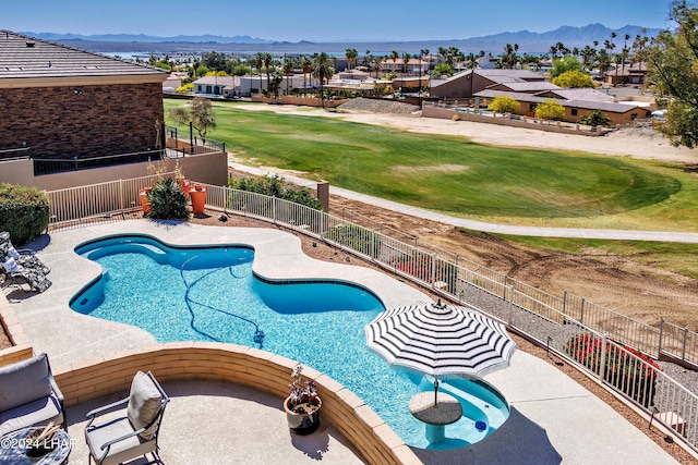 view of swimming pool with a patio, a mountain view, and a yard