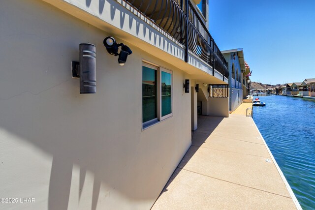 8652 Hopi Dr, Parker, AZ 85344 - view of property exterior featuring stucco siding, a water view, and a boat dock