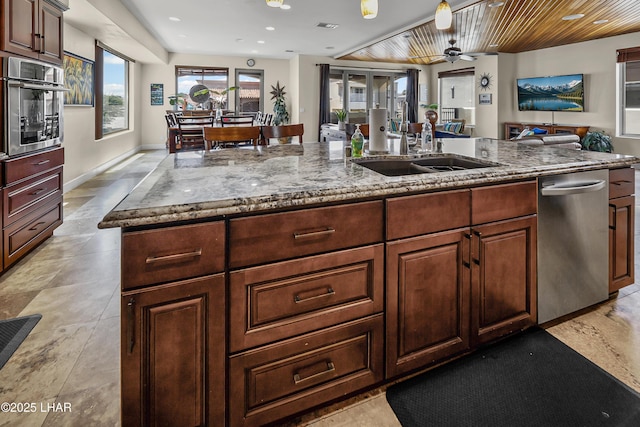 8652 Hopi Dr, Parker, AZ 85344 - kitchen with stainless steel appliances, an island with sink, open floor plan, light stone counters, and recessed lighting