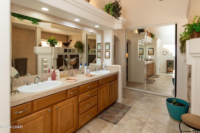 bathroom with double vanity, tile patterned flooring, a sink, and recessed lighting