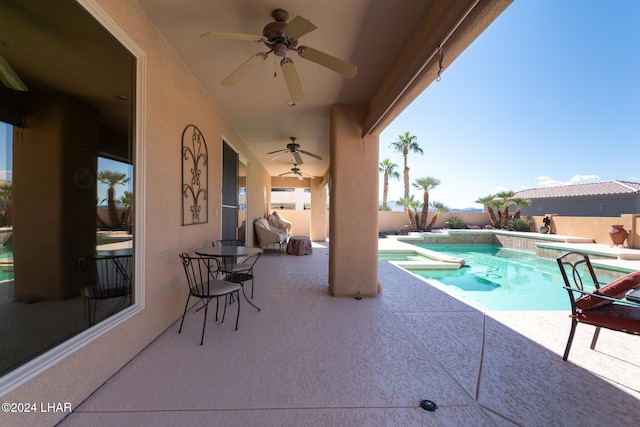 view of swimming pool featuring a fenced backyard, a pool with connected hot tub, a ceiling fan, and a patio