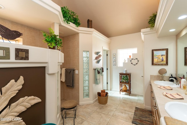 full bath featuring double vanity, a walk in shower, a sink, and recessed lighting