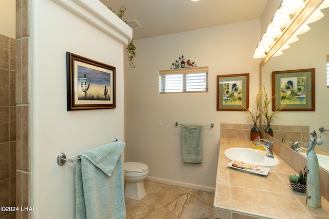 bathroom with baseboards, visible vents, vanity, and toilet