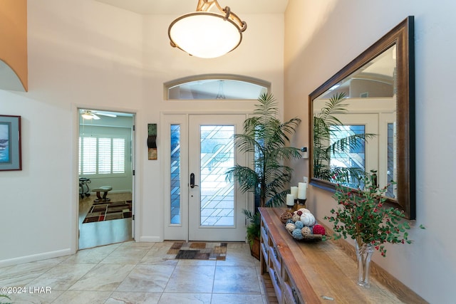 entrance foyer featuring a towering ceiling and baseboards