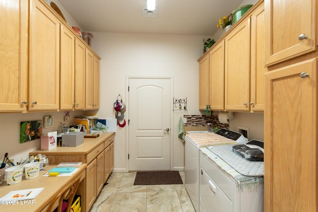 clothes washing area with marble finish floor, washer and clothes dryer, and cabinet space