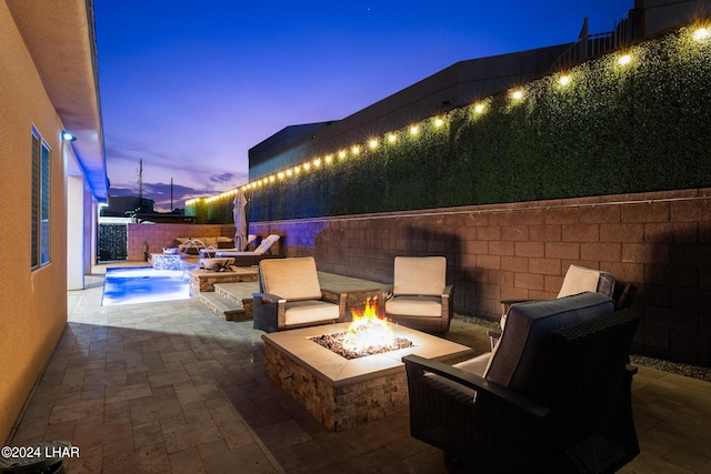 patio terrace at dusk featuring a fire pit