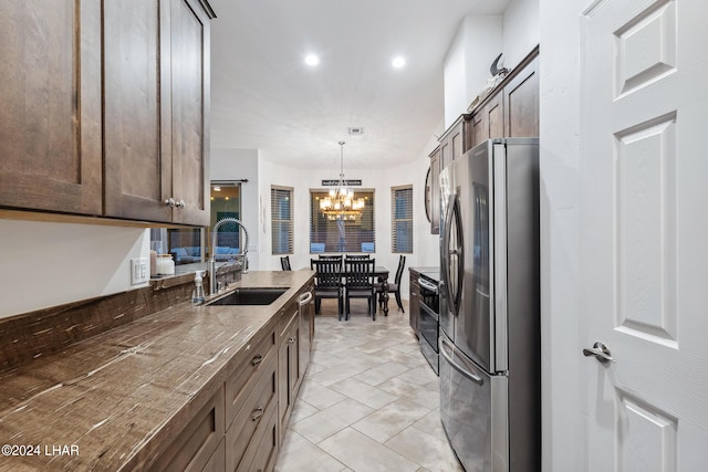 kitchen featuring sink, hanging light fixtures, a chandelier, and appliances with stainless steel finishes