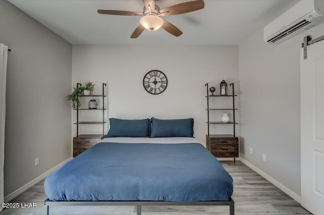 2950 N Kiowa Blvd Unit A101, Lake Havasu City, AZ 86404 - bedroom with a wall mounted air conditioner, wood finished floors, a barn door, and a ceiling fan