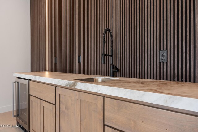 interior space with wine cooler, butcher block countertops, sink, and light brown cabinets