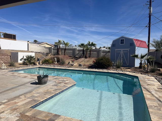 view of pool featuring a shed and a patio