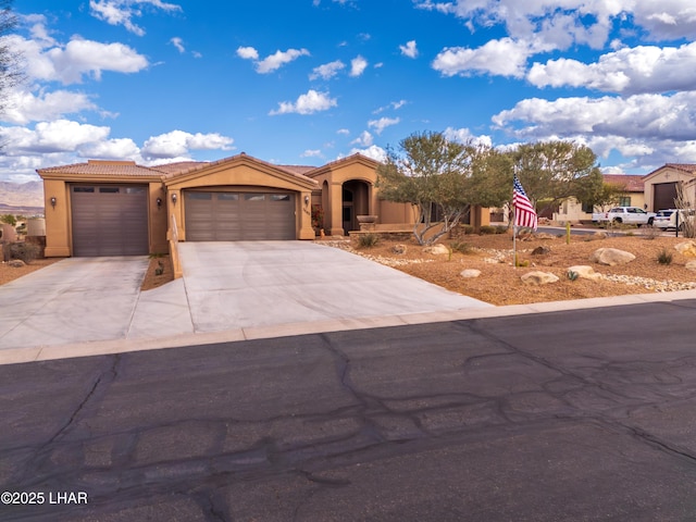 view of front of home with a garage, a tiled roof, and stucco siding