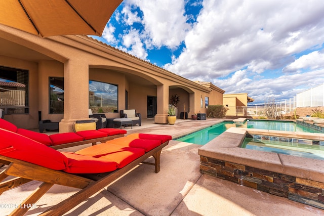 pool featuring a patio area, fence, and an in ground hot tub