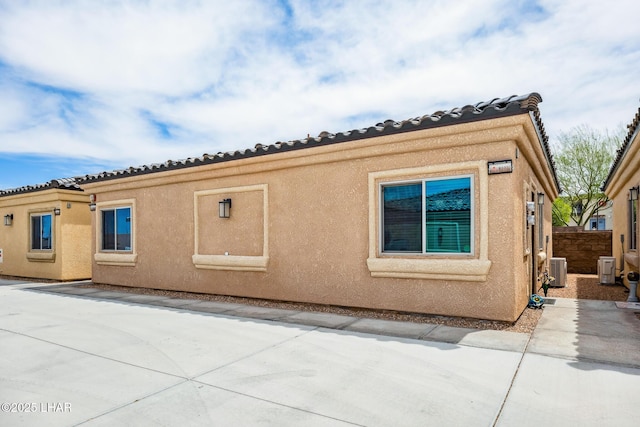 2950 N Kiowa Blvd Unit B102, Lake Havasu City, AZ 86404 - view of side of property featuring central AC, fence, stucco siding, and a patio