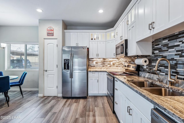 2950 N Kiowa Blvd Unit B102, Lake Havasu City, AZ 86404 - kitchen featuring appliances with stainless steel finishes, a sink, decorative backsplash, white cabinets, and light wood-type flooring