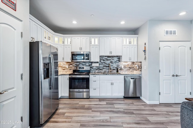 2950 N Kiowa Blvd Unit B102, Lake Havasu City, AZ 86404 - kitchen with stainless steel appliances, a sink, recessed lighting, white cabinets, and decorative backsplash