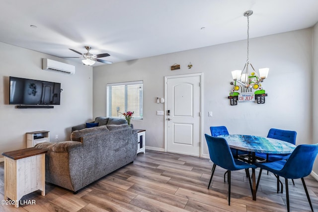 2950 N Kiowa Blvd Unit B102, Lake Havasu City, AZ 86404 - living area with a chandelier, a ceiling fan, wood finished floors, a wall mounted air conditioner, and baseboards