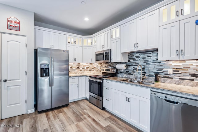 2950 N Kiowa Blvd Unit B102, Lake Havasu City, AZ 86404 - kitchen with stainless steel appliances, a sink, light stone countertops, white cabinets, and decorative backsplash