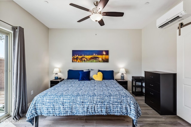 2950 N Kiowa Blvd Unit B102, Lake Havasu City, AZ 86404 - bedroom with an AC wall unit, a barn door, wood finished floors, and ceiling fan