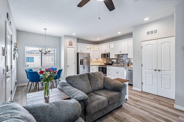 2950 N Kiowa Blvd Unit B102, Lake Havasu City, AZ 86404 - living area with a chandelier, light wood-type flooring, baseboards, ceiling fan, and recessed lighting