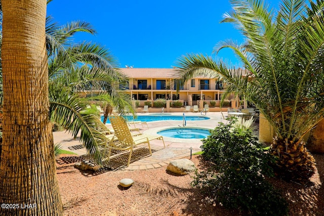 view of pool with a hot tub and a patio