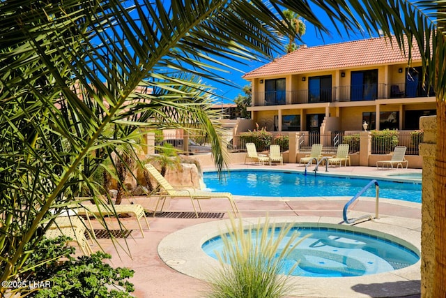 view of swimming pool with a community hot tub and a patio