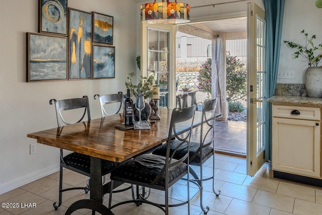 dining room featuring light tile patterned flooring and baseboards