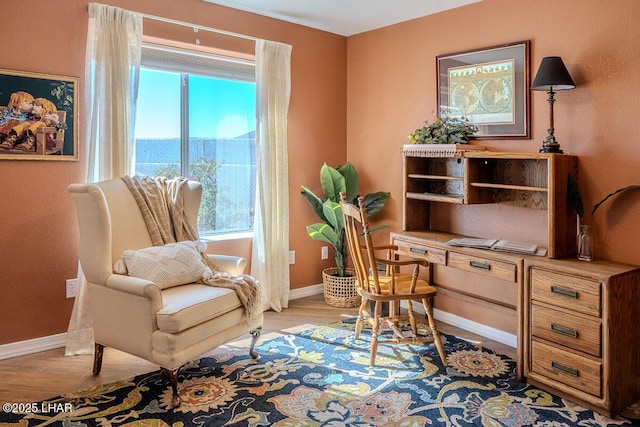 living area with wood finished floors and baseboards