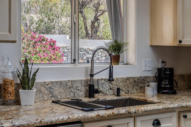 kitchen with a sink and light stone countertops