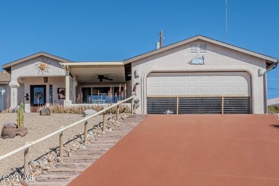 view of front facade with a garage, driveway, and a ceiling fan