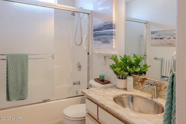 bathroom with toilet, enclosed tub / shower combo, and vanity