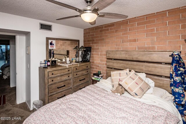 bedroom featuring brick wall, ceiling fan, carpet, and a textured ceiling