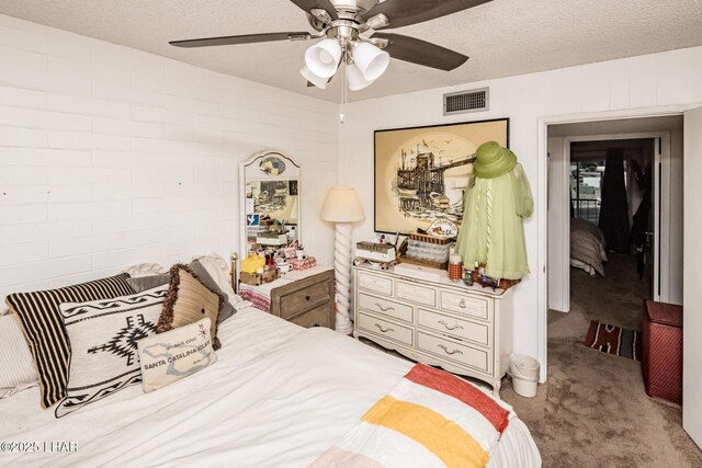 carpeted bedroom featuring ceiling fan and a textured ceiling